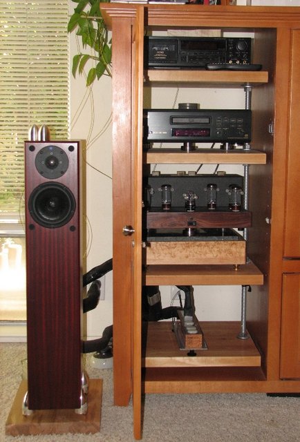 The rack... - ...has been isolated from the entertainment center by cutting 1" holes in the cabinet shelf and the ends of the rods have been ground into spikes to pierce the carpet and make contact with the cement slab below. My D.I.Y. Flexy rack was built with Â¾' threaded rods, 1Â½' maple shelves and has been grounded.