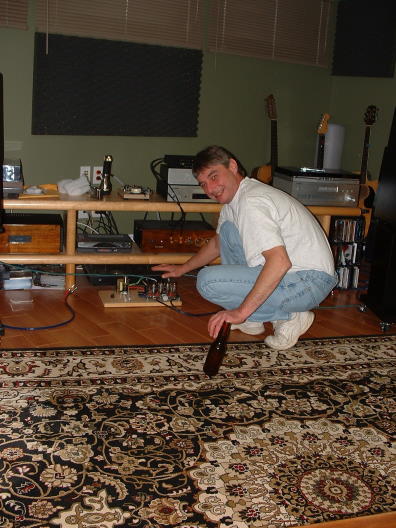 DSCF 0008.JPG - Mark has quite a unique "style" of multitasking. Here we see him: balancing himself while squating and warming his one free hand on the "naked amp"...note the Canadian beverage close by.