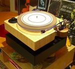 Modify MFF 7 turntable - Completely modify MMF 7 with Bamboo plinth and same stand in black. Arm board is adj. to accommodate different arms - made out of walnut solid piece of wood with two steel rods for distance adj. Arm is Moarch up4 with Denon 103R cart. New plinth and stand added some weight to the original cheap design with funny balls between the layers of MDF. Not criticizing the original design - it is a great turntable for the money but out of boredom I decided to overhaul it as much as possible on the very little budget. You can do the same : buy the motor , platter, belt and spindle for around $150-$200. Bamboo butcher block 2X $40 = $80 from TJMax, scrap piece of solid wood from local wood shop = free, paint and accessories = $50. Grand total = around $300 for necessary parts. Add arm and cart of your choice. Denon 103 and Rega arm would be a good starting combo. Enjoy.