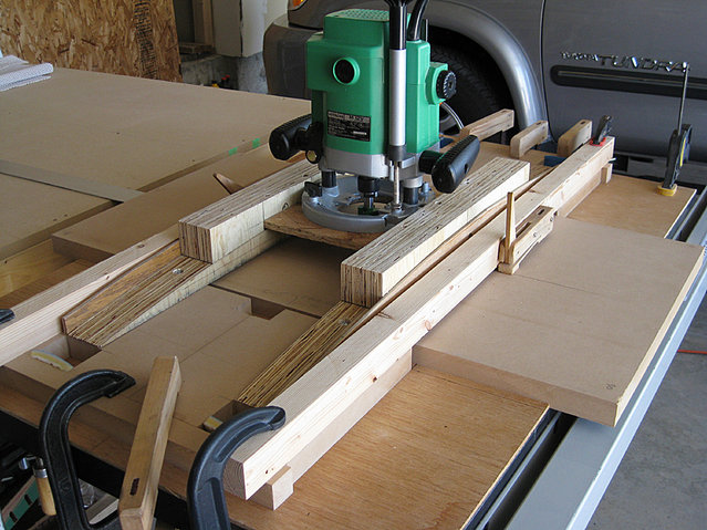 IMG 0245.JPG - As the router is slid back and forth, the side being cut will be pushed under the router. I used the top half of some cam clamps to act as hold-downs to the side piece.