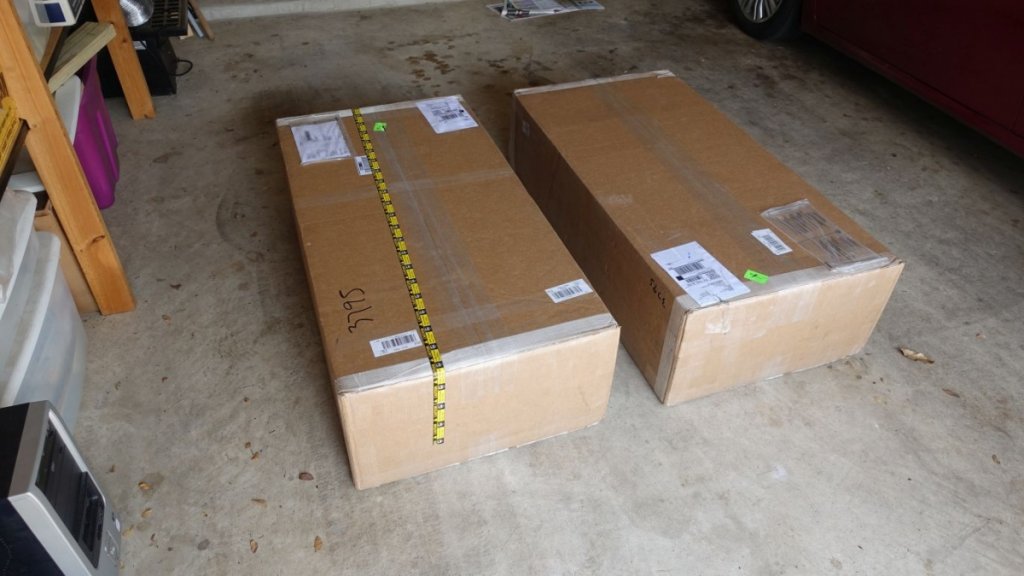 Two boxes, each containing the flat pack for a triple servo sub