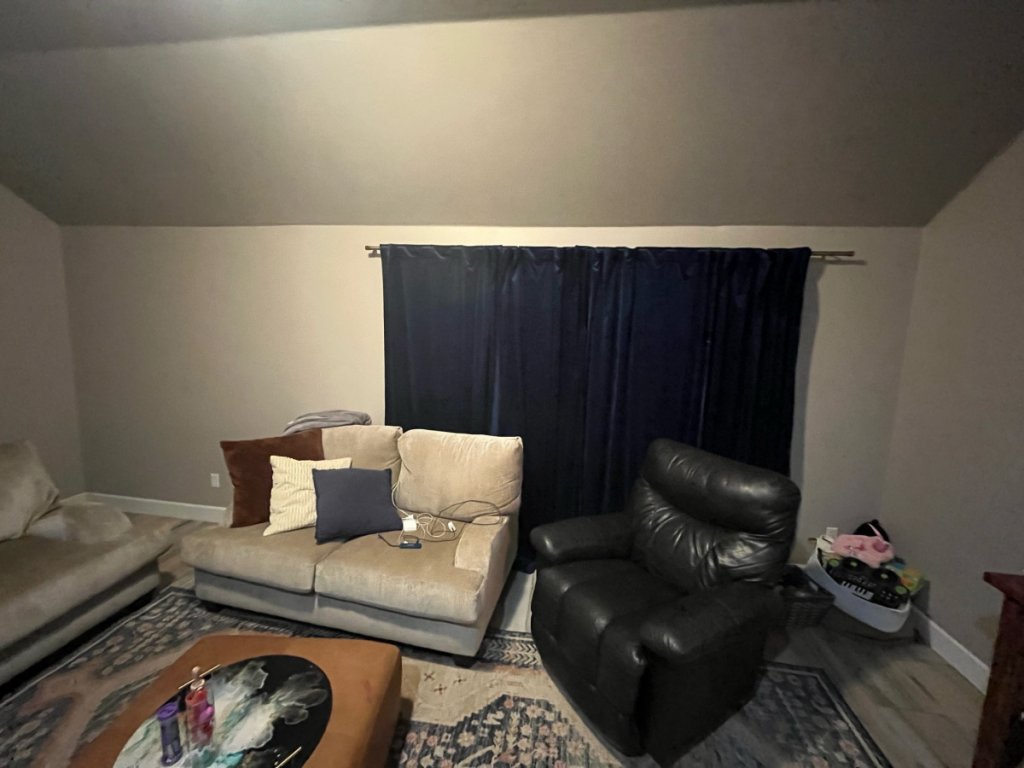 Right side of the room. The drapes cover about half of the side wall