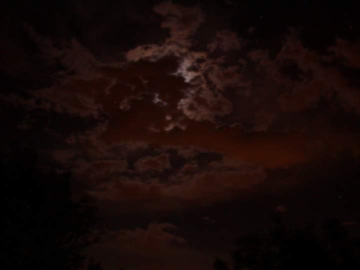 A beautiful night with a full moon drifting behind clouds