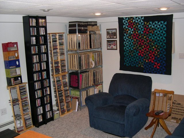 A view of the listening chair. Lots of albums & CD's in easy reach. My wife made the quilt hanging over the room treatment behind the seat.