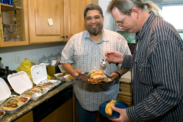 Chris is stealing food from Wes while he is posing for picture.