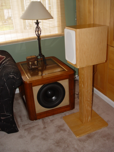 Sub in place but not complete - Sub is still in raw MDF but is usable, I couldn't wait. Wife was upset about another big box so I took one of our end tables and removed the bottom and now it slips over the sub. I also added large casters to the bottom for easy vacuuming. End table top is easily removed for serious listening. You can see my A/V-1 also in the picture. I plan to veneer the sub and hide it a bit more.