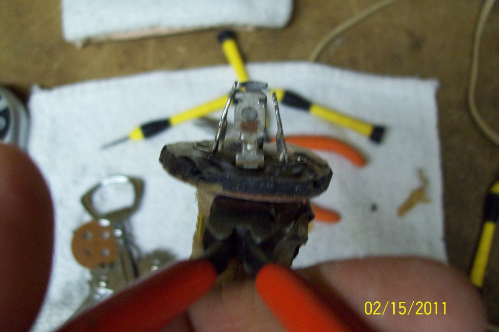 Removing the old capacitor from the lug plate with wire cutters..
