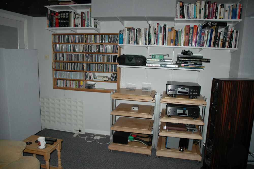 A Soffit Bass Trap by the ceiling. The Gear is a TEAC P/70 CD Transport, TEAC D/70 DAC, Behringer DEQ2496, Son of Ampzilla amp, and on the other rack a Shunyata Hydra 8 power conditioner. Cables are mostly Shunyata. Racks are Finite Elemente Pagoda Reference. The Transport and amp each sit on four Townshend Seismic Isolation Pods.